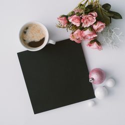 Coffee, decorations and dark paper card with flowers