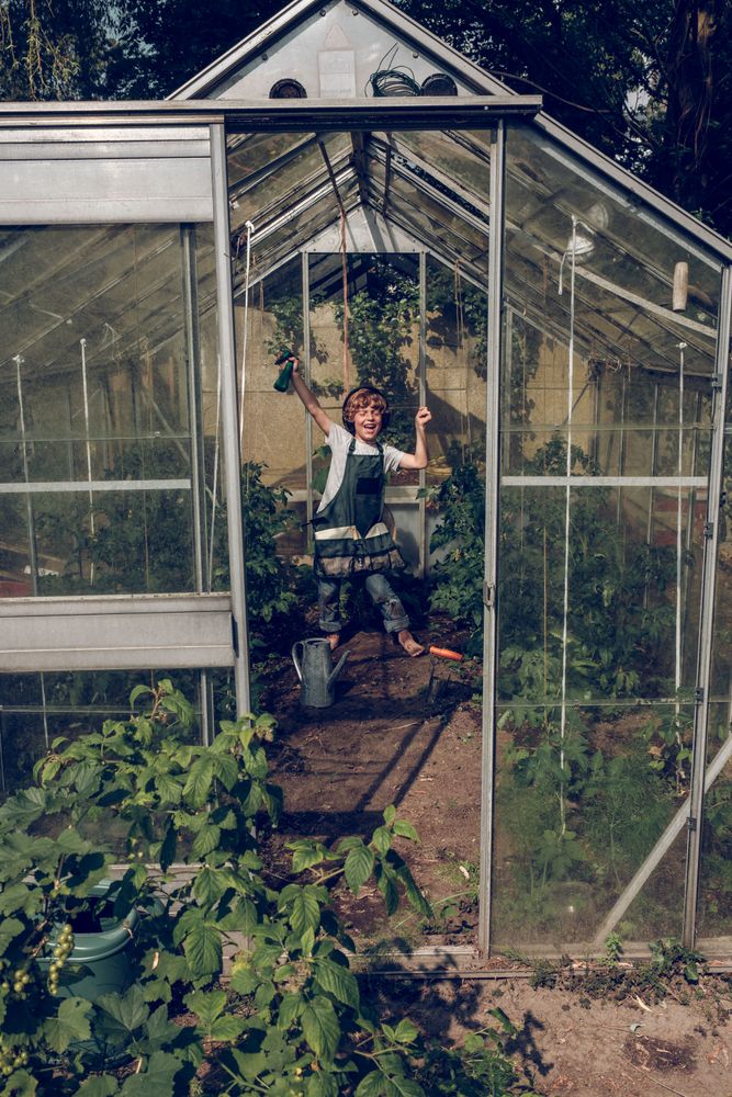 Excited kid in headphones in glasshouse