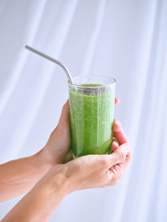 Unrecognizable person with glass of smoothie