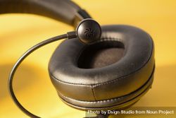 Single headphone ear speaker & mic on yellow table 4d81Ya