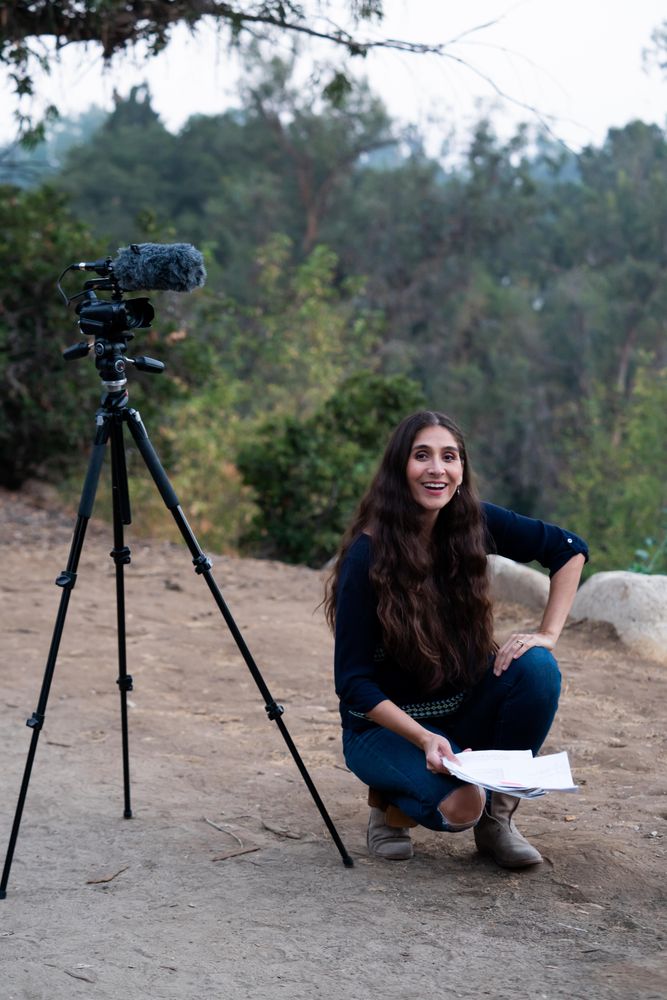 Female director kneeling next to camera outside