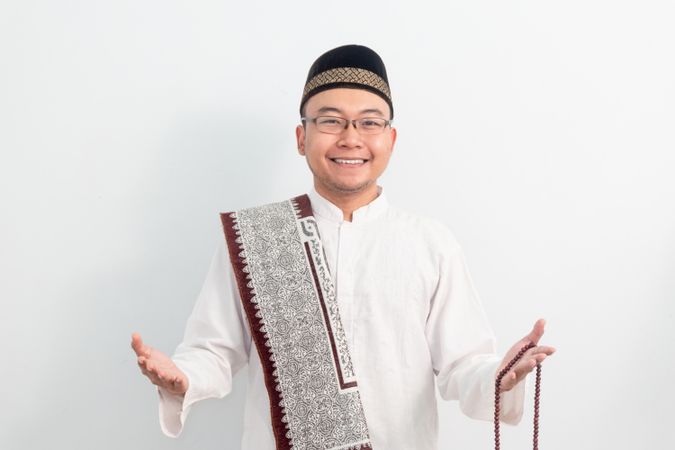 Asian Muslim man smiling doing greeting pose during Ramadan