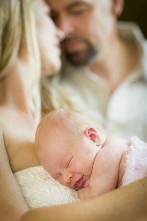 Loving Young Couple Holding Their Newborn Baby Girl