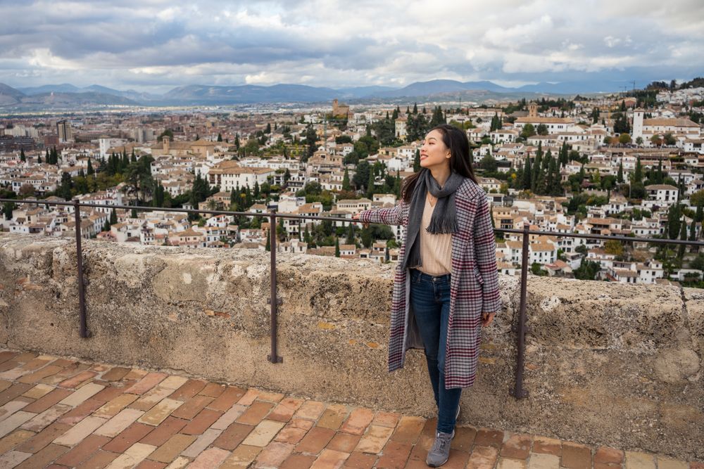 Cheerful woman visiting ancient city