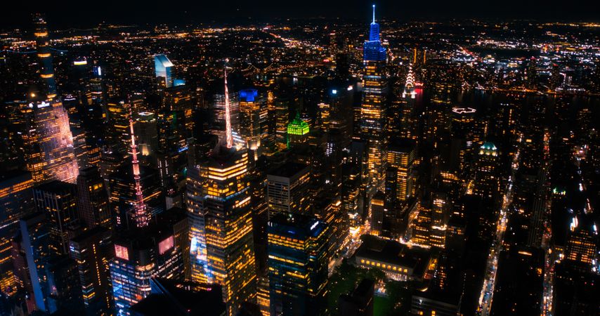 Aerial Shot of Office Buildings at Night. Rooms Have Lights On, Businesspeople and Managers Working Long Hours in New York City. Helicopter Cityscape View of Manhattan in the Evening