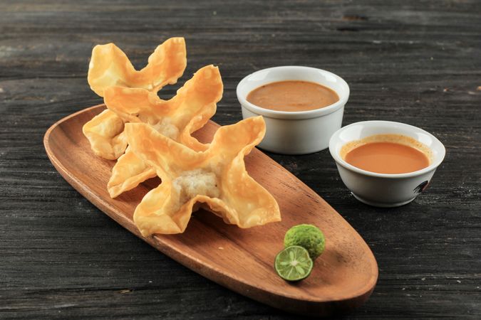 Deep fried wonton appetizer with peanut sauce and lime