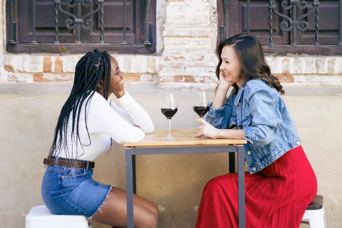 Female friends enjoying wine at an outdoor table at a restaurant