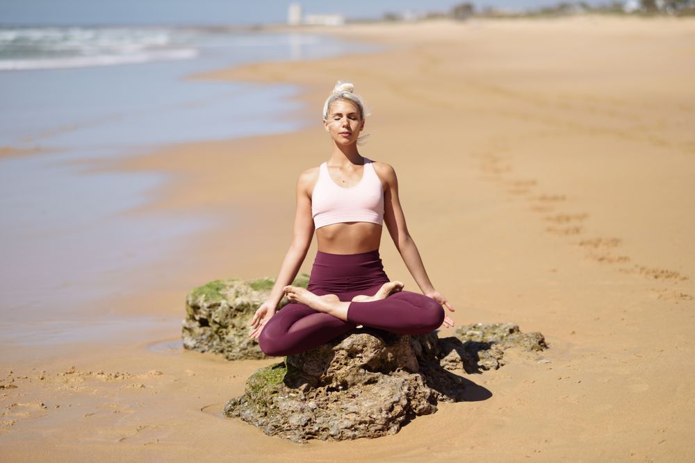 Calm woman practicing meditation on a Spanish beach