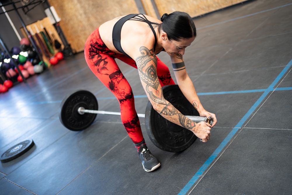 Women prepping barbell before lifting
