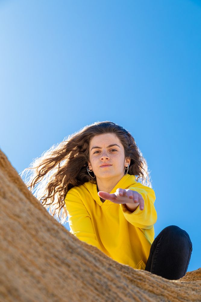 Young female lending helping hand in mountains