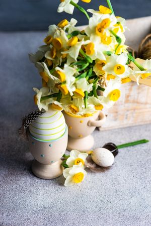 Easter floral card concept with daffodils and egg cups
