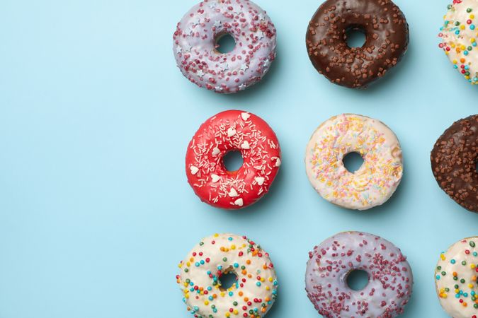 Flat lay with tasty donuts on blue background
