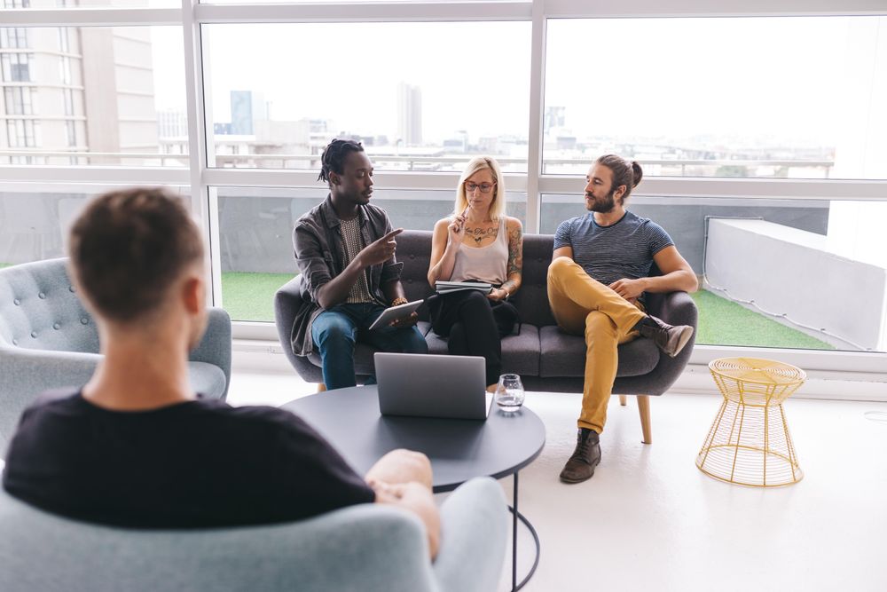 Group of co-workers having a discussion in a bright modern office