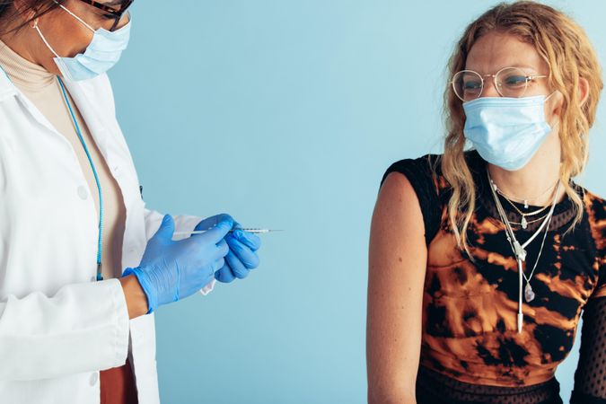 Young woman wearing face mask at clinic getting covid-19 vaccine