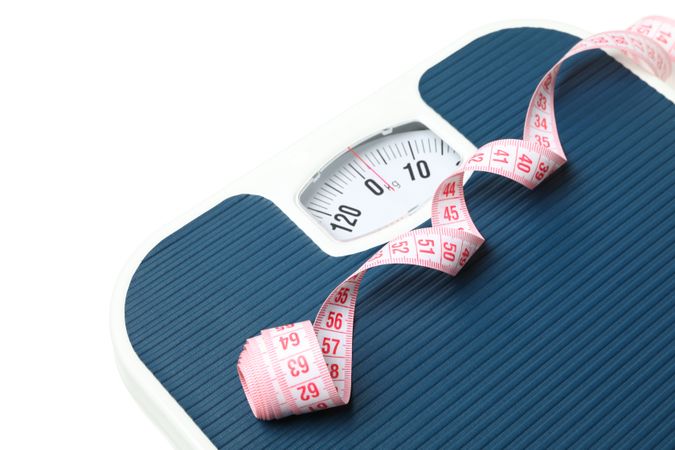 Scales and measuring tape isolated on light background