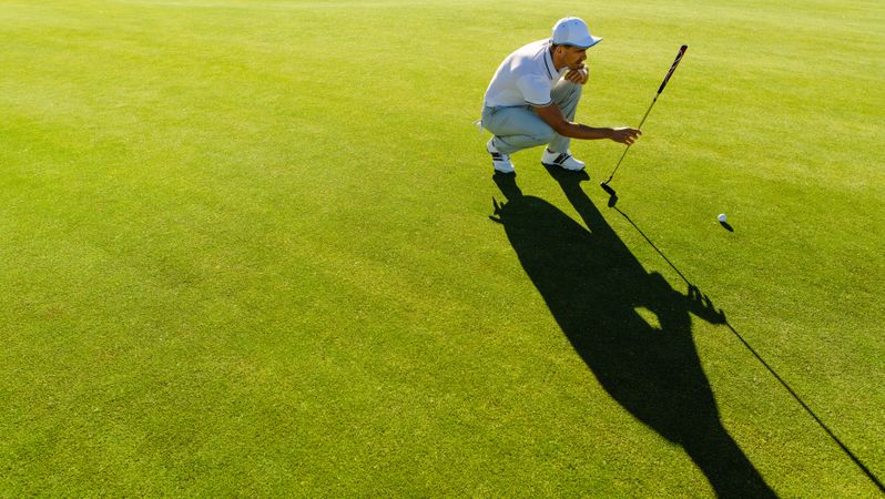 Golf player studying the green before putting shot