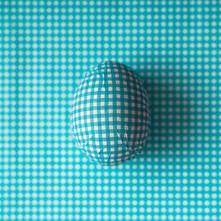 Blue checkered Easter egg with matching background