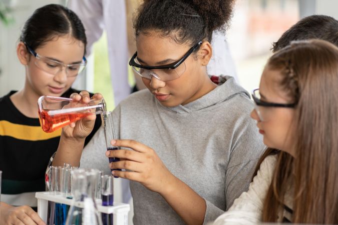 Multi-ethnic girls in science class doing chemical experiment in laboratory