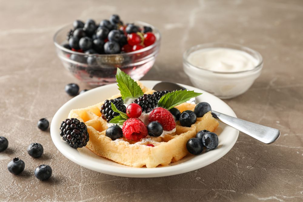 Composition of breakfast with belgian waffles, space for text