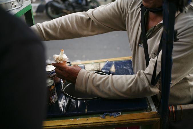 Street vendor in Indonesia putting chocolate sauce on ice cream