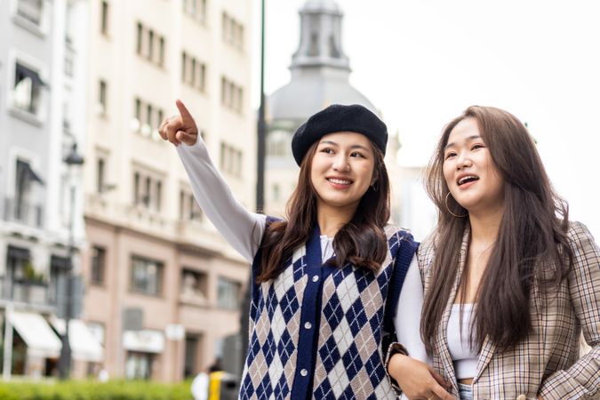Asian young female friends walking on the street in the city