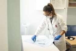 Young doctor with scissors and tweezers on napkin