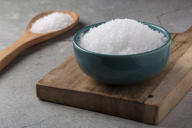 Bowl with coarse salt on the table.