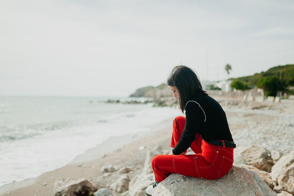 stylish woman looking down in calm sea
