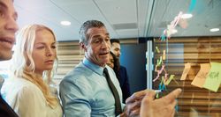 Group of people in business attire brainstorming with sticky notes
