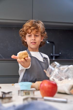 Boy with cookie dough in kitchen