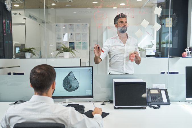 Serious men analyzing diagrams of creating protective masks