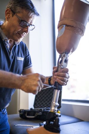 man fixing a prosthesis in a workshop