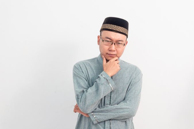 Thoughtful Muslim man doing thinking gesture in Ramadan