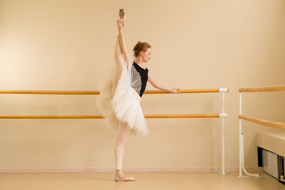 Ballet dancer performing high leg stretch