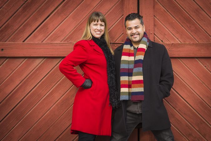Couple Portrait in Winter Clothing Against Barn Door