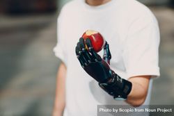 Cropped image of man with prosthetic hand holding a red apple 5nKL64