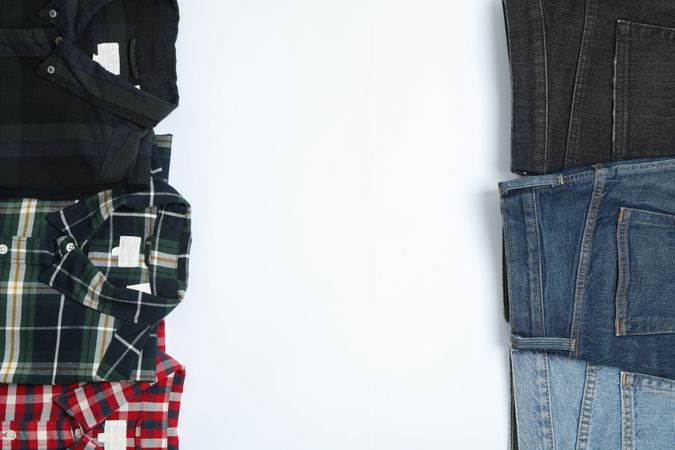Flat lay with shirts and jeans on plain background