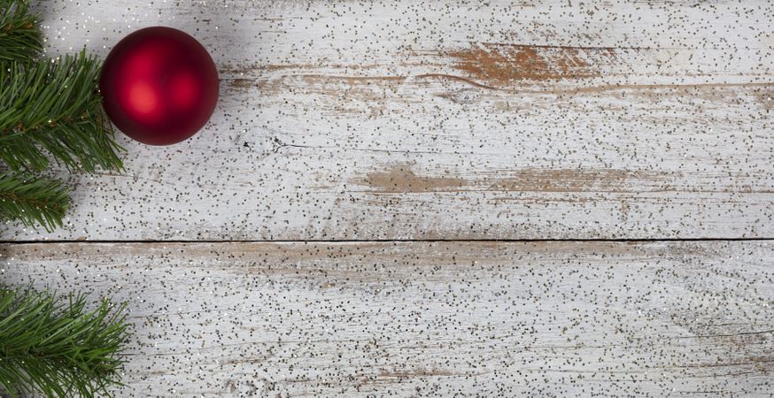 Single red ornament on rustic wood for Christmas or New Year holiday concept background