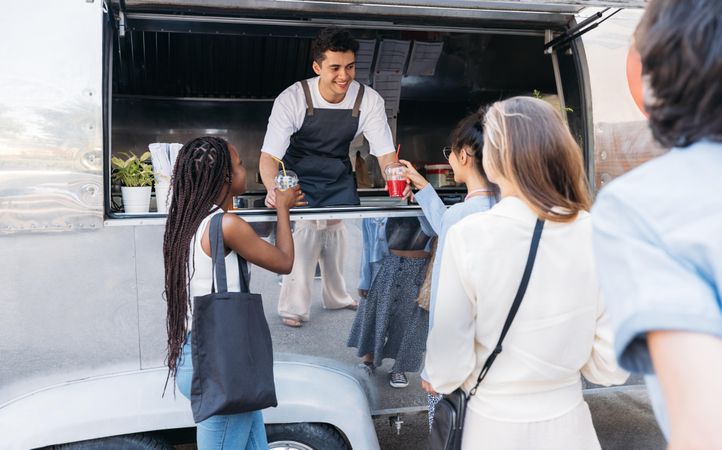 Smiling food vendor selling drinks to customers