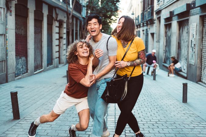 Funny multiracial friends having fun along city street