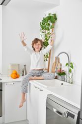 Cheerful boy showing soapy palms while cleaning hands in kitchen