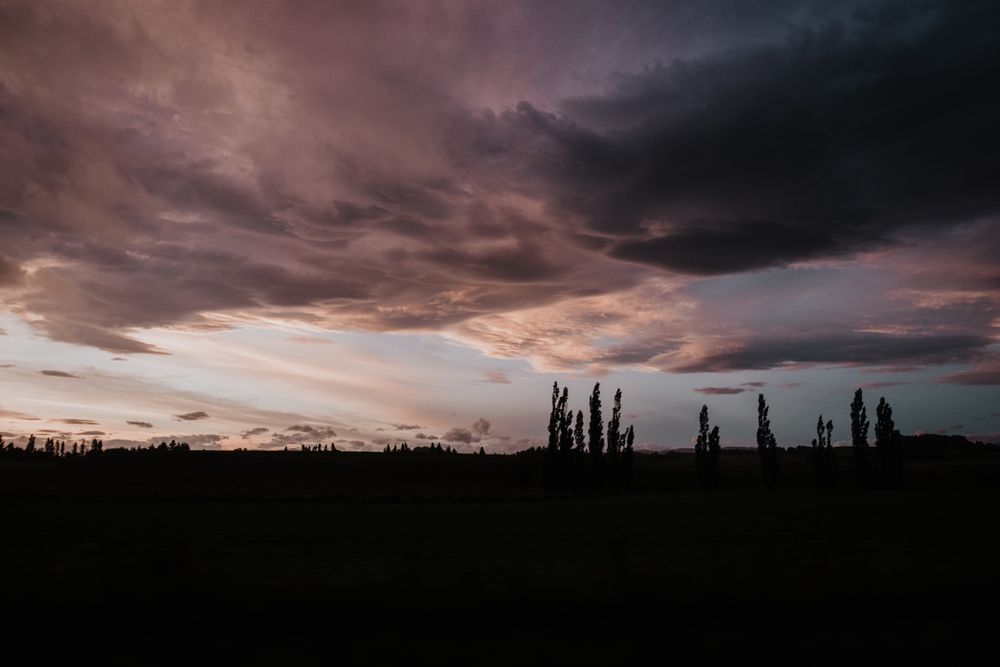 Evening cloudy sky above dark field