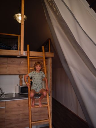 Cute boy on ladder on terrace