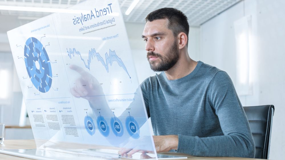 In the Near Future Successful Trader Works on Computer with Transparent Display that Shows Interactive Line Charts