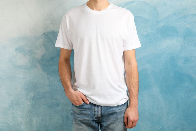 Men in blank t-shirt against blue background, space for text