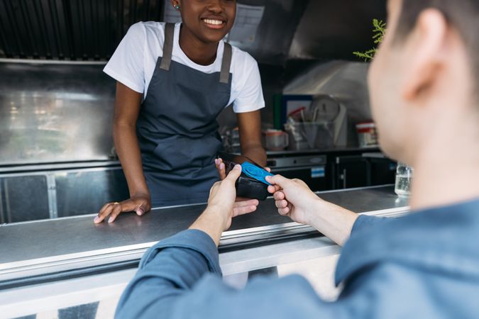 Male paying food truck vendor with tap card