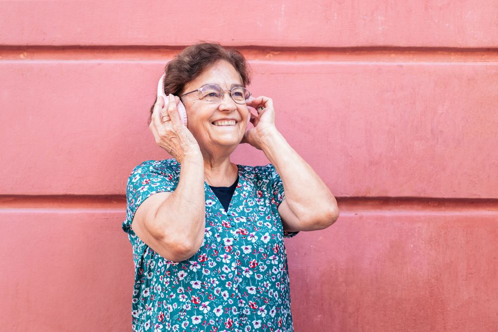 Mature woman in colorful clothes and modern headphones