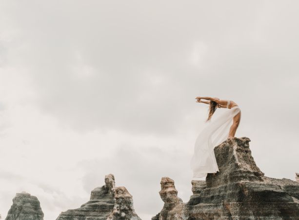 Anonymous female exercising on top of rock