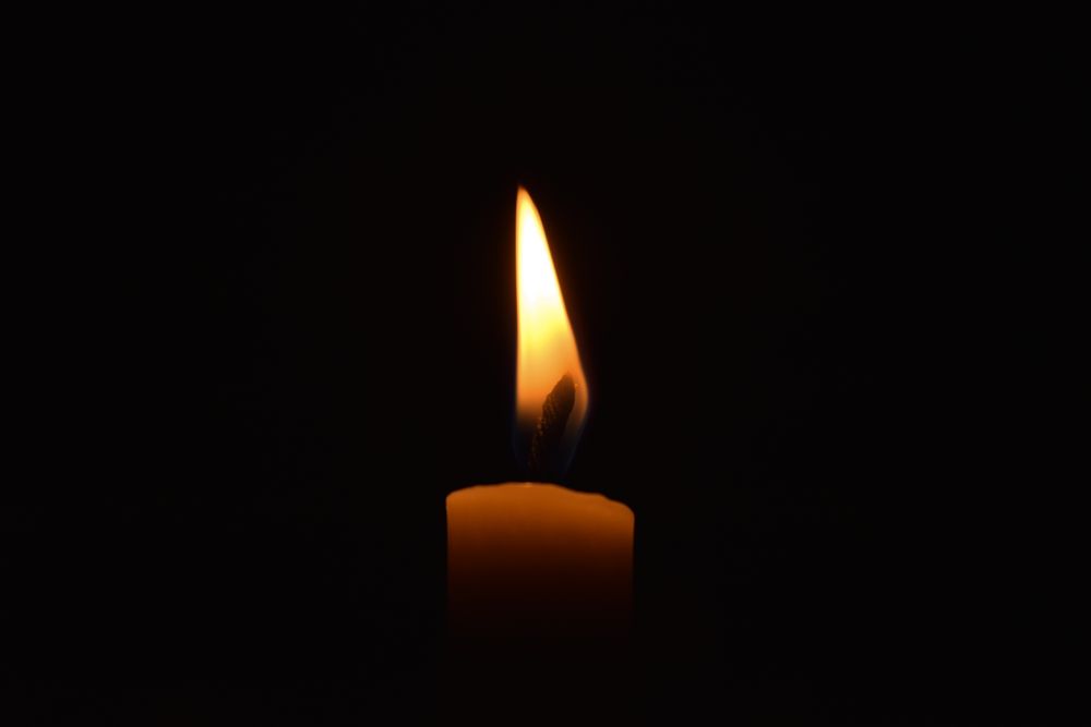 Side view of candle burning in the dark