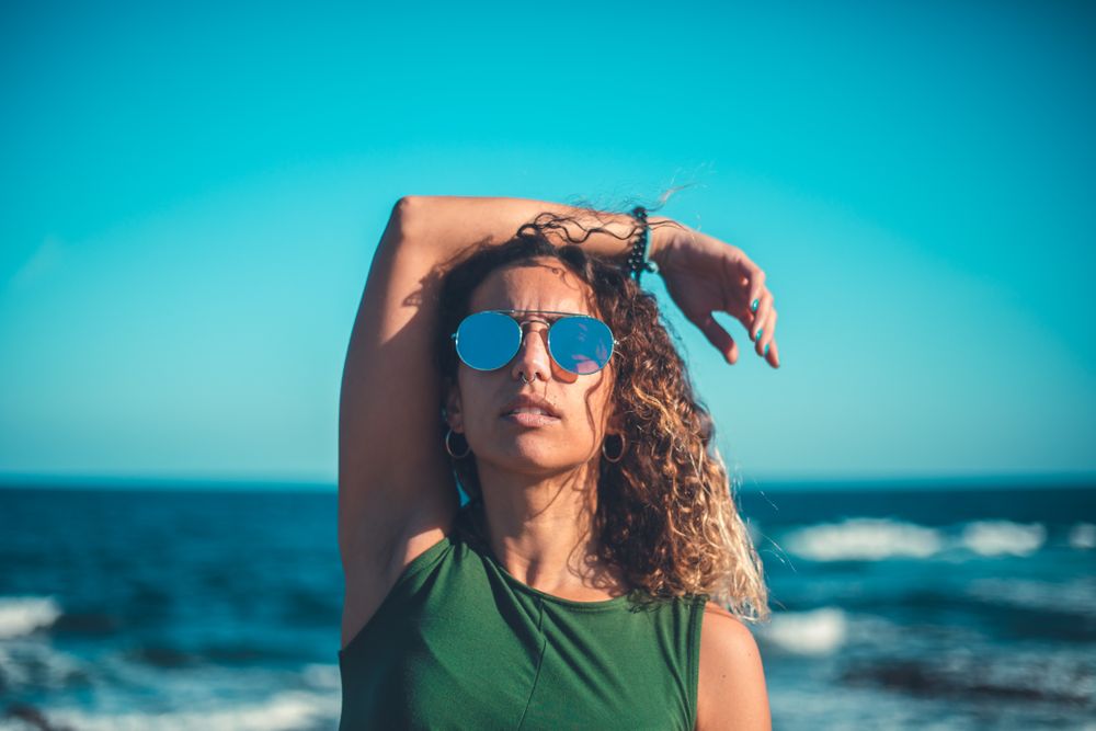 Stylish woman standing near sea